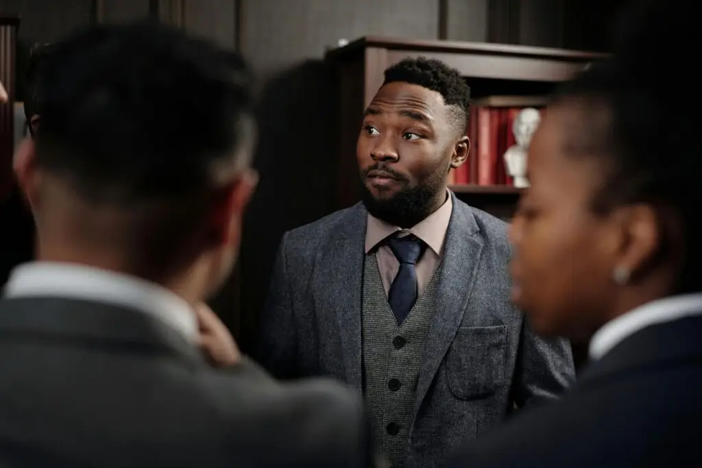 Group of business professionals in discussion inside an office setting.